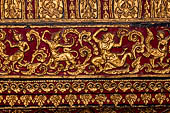 Wat Xieng Thong temple in Luang Prabang, Laos. Gilded carvings on a red background decorating the interior of the sim.